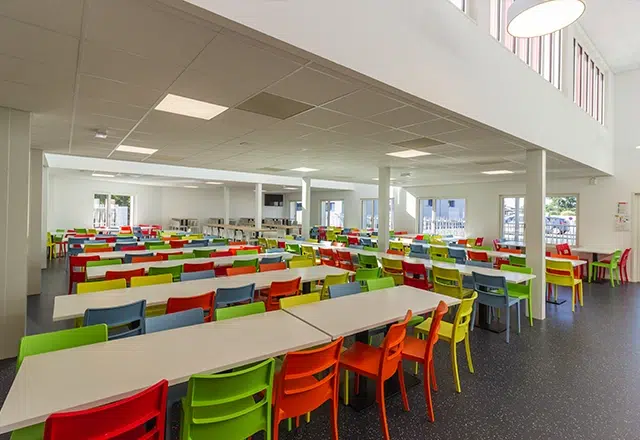Construction restaurant scolaire ou cantines réfectoire chaises oranges et vertes