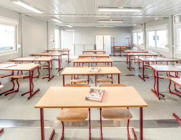 Salle de classe avec tables et chaises rouges pour la location d'une école modulaire